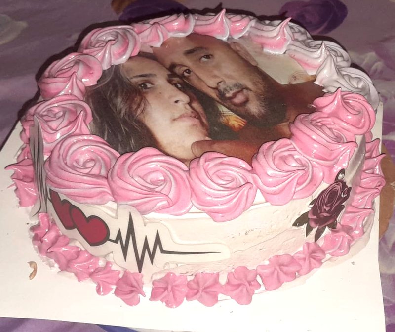 Cake con una foto de pareja impresa, rodeada de rosas de merengue
