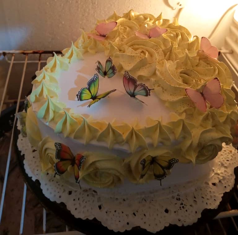 Cake de merengue amarillo y blanco con mariposas comestibles